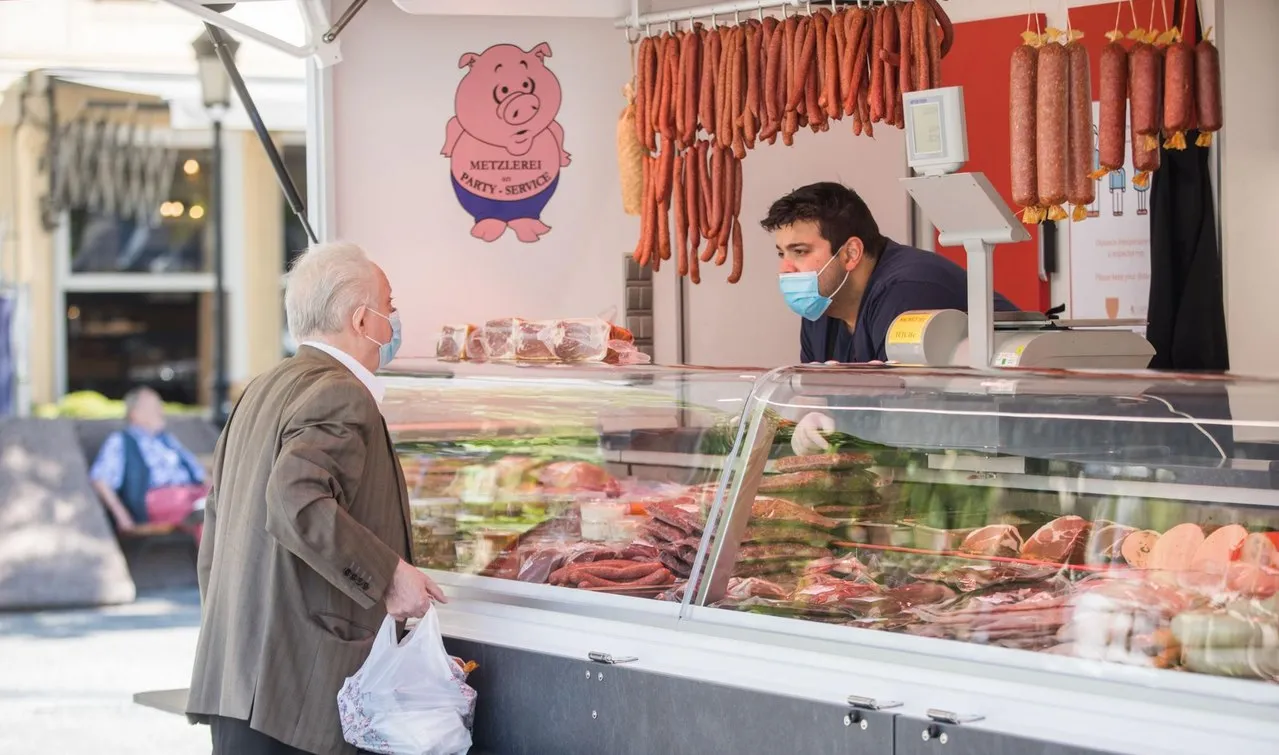 Kunde wird an der gut gefüllten Theke des Beim Burg Verkaufswagens auf einem Markt bedient